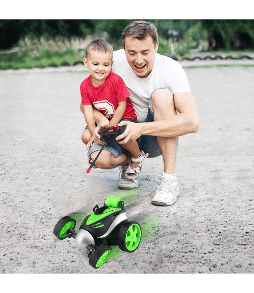 Padre e hijo jugando con el coche de acrobacias con control remoto.